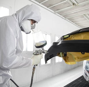 Collision Center Technician Painting a Vehicle | Parkersburg Toyota in Parkersburg WV